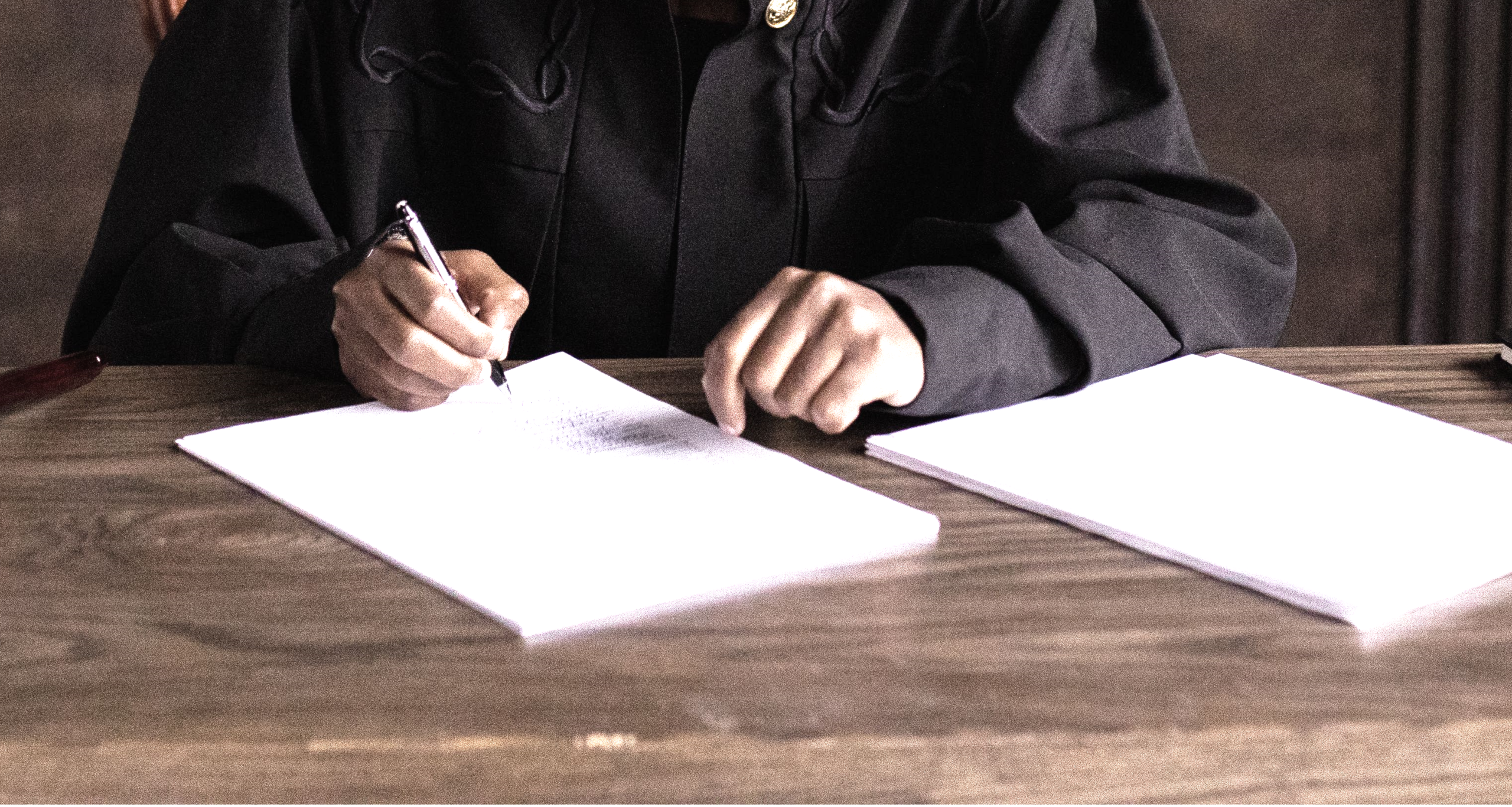 Two people reviewing and signing documents at a table