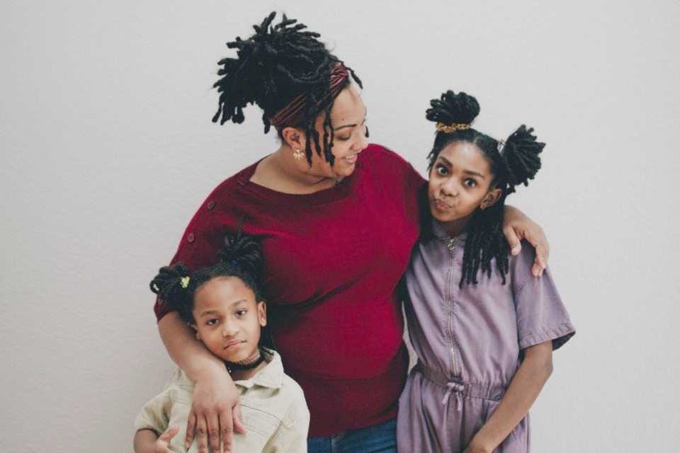 A mother with her arms around her two daughters